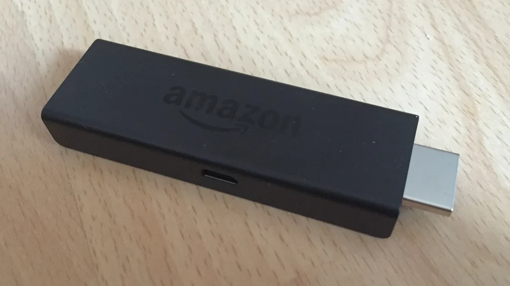 Amazon Fire TV Stick streaming device on a light wooden table