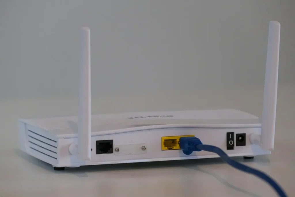 Back of a white home broadband router with an Ethernet cable plugged in, as used for a wired Chromecast setup