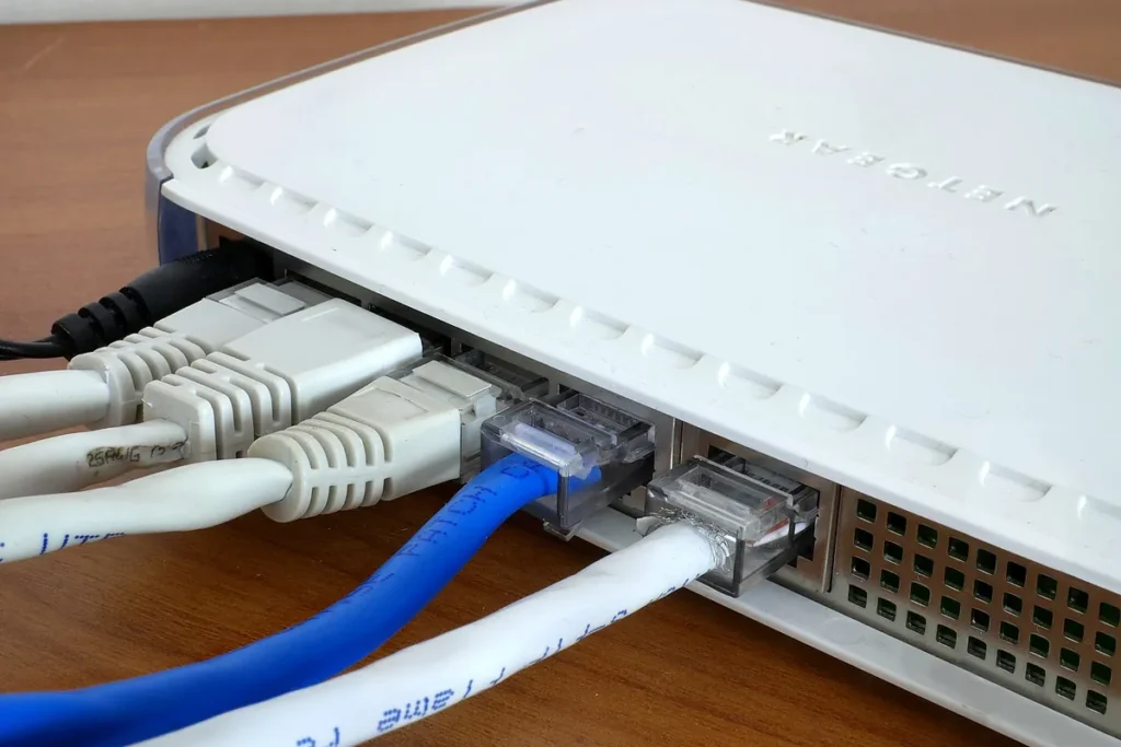 Several Ethernet cables plugged into the back of a home broadband router
