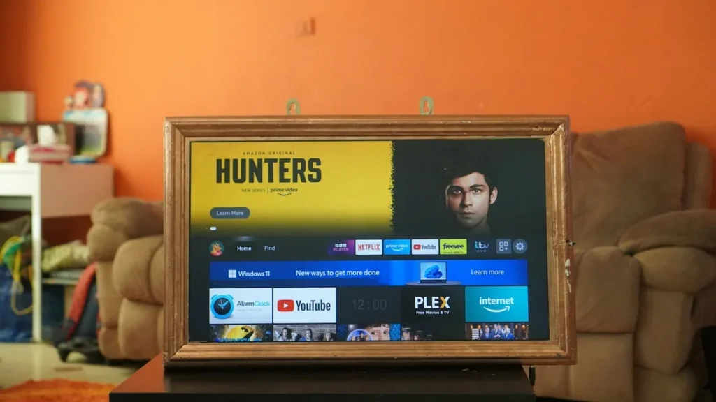 Fire TV home screen with BBC iPlayer, ITV and other UK app tiles on a TV in a living room