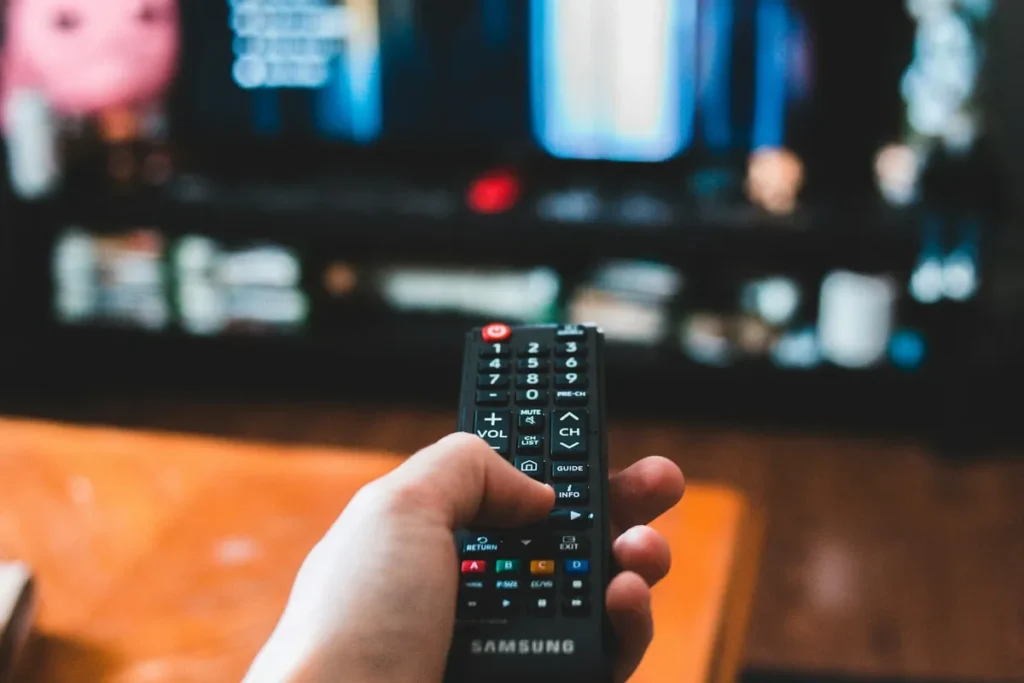 Hand pointing a TV remote at a smart TV menu, the built-in alternative to a smart TV box