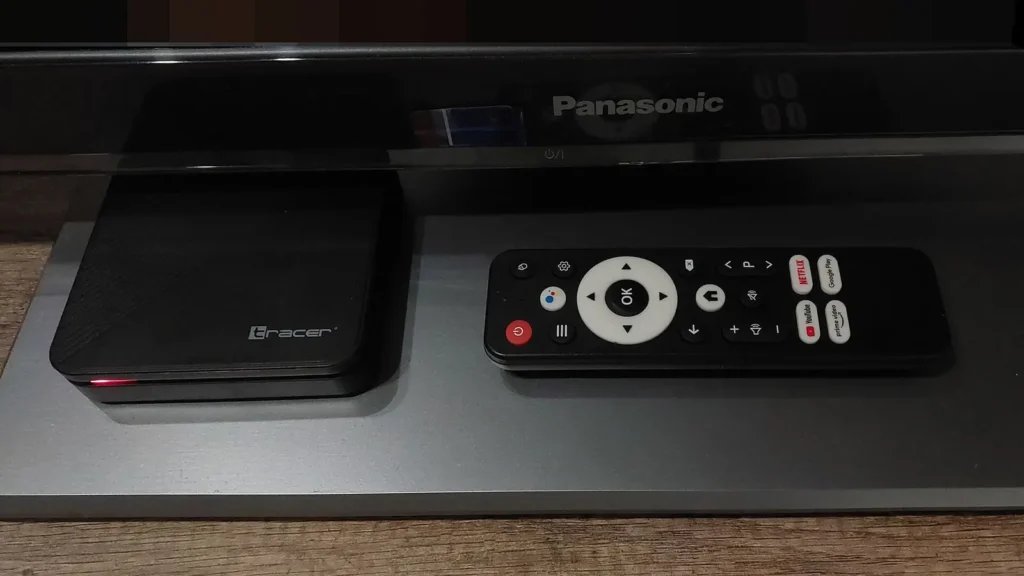 Android TV set-top box and remote under a television, the kind of device where TiviMate vs IPTV Smarters is a real choice